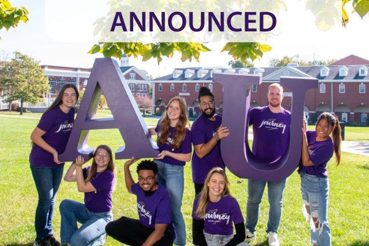 students smiling and holding the letters A and U on the Asbury University green lawn